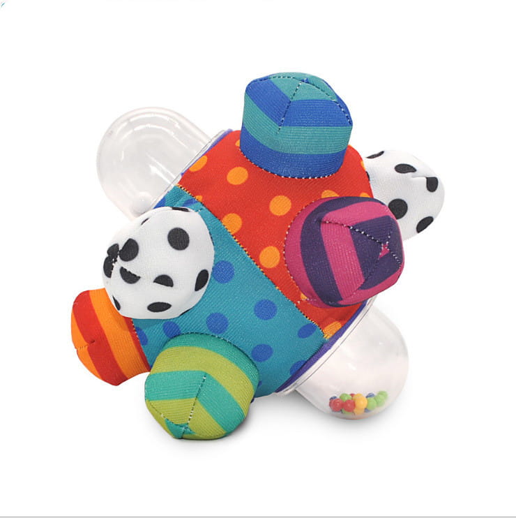 A colorful patchwork plush baby rattle ball grasping toy with polka dots and stripes in vibrant orange teal pink and green designed for sensory play.