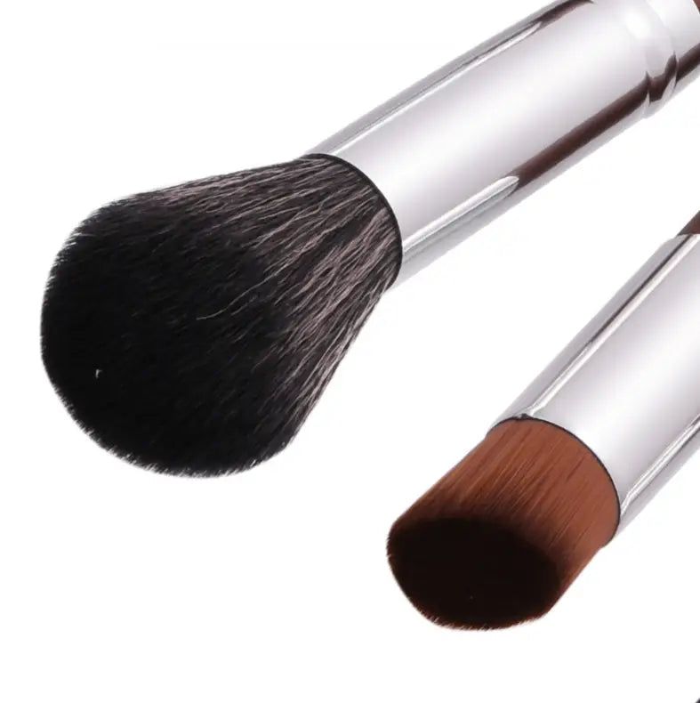 Silver-handled makeup brush set includes two brushes with dense soft black bristles on one and a tapered brown tip on the other for professional application in a 10 piece silver wood collection.
