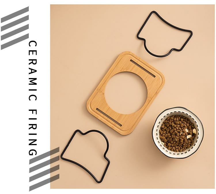 Rectangular bamboo ceramic cat bowl with black rim and white interior filled with brown kibble on elevated wooden stand.