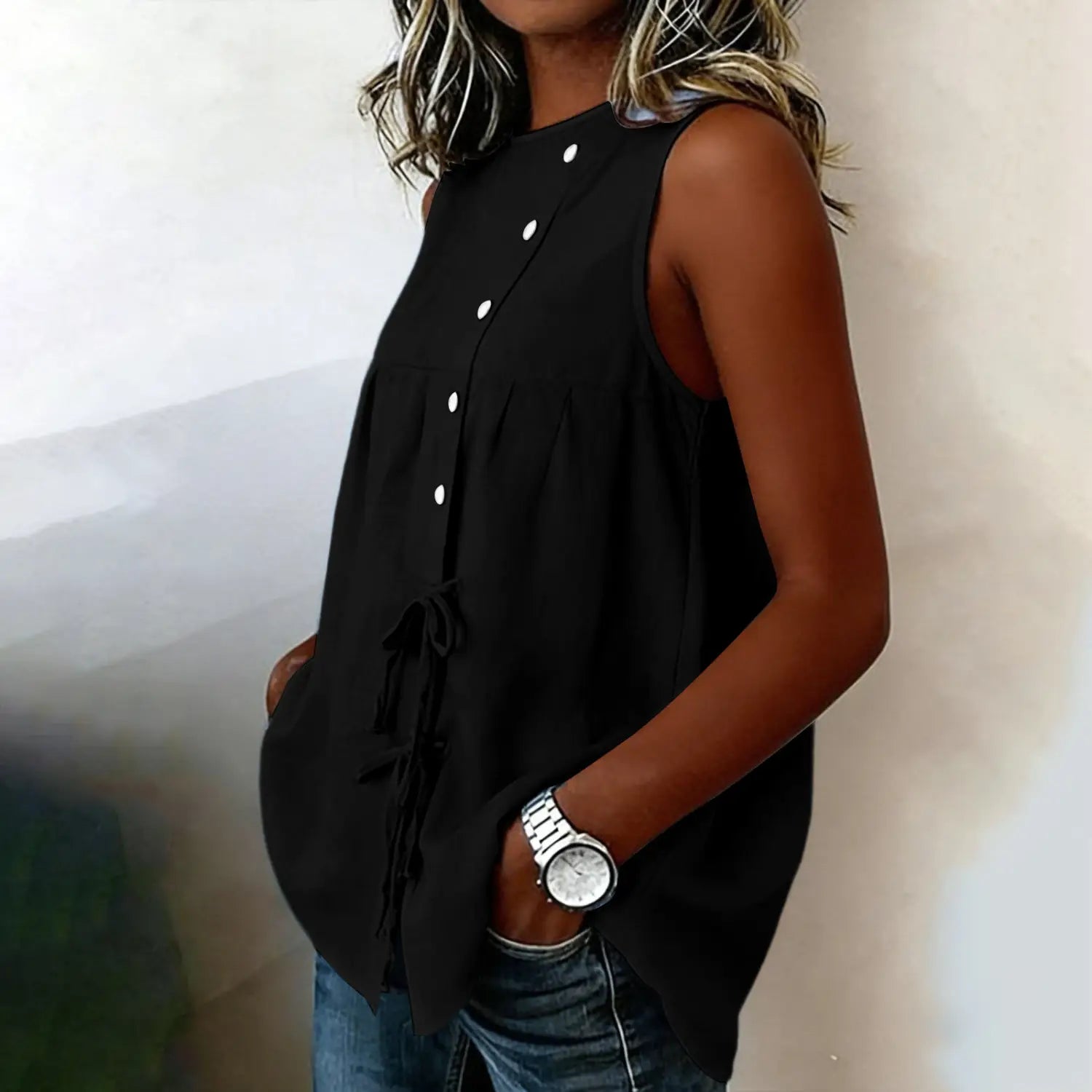 Black sleeveless tie side button down blouse featuring white buttons and a waist tie detail for a stylish and elegant look.