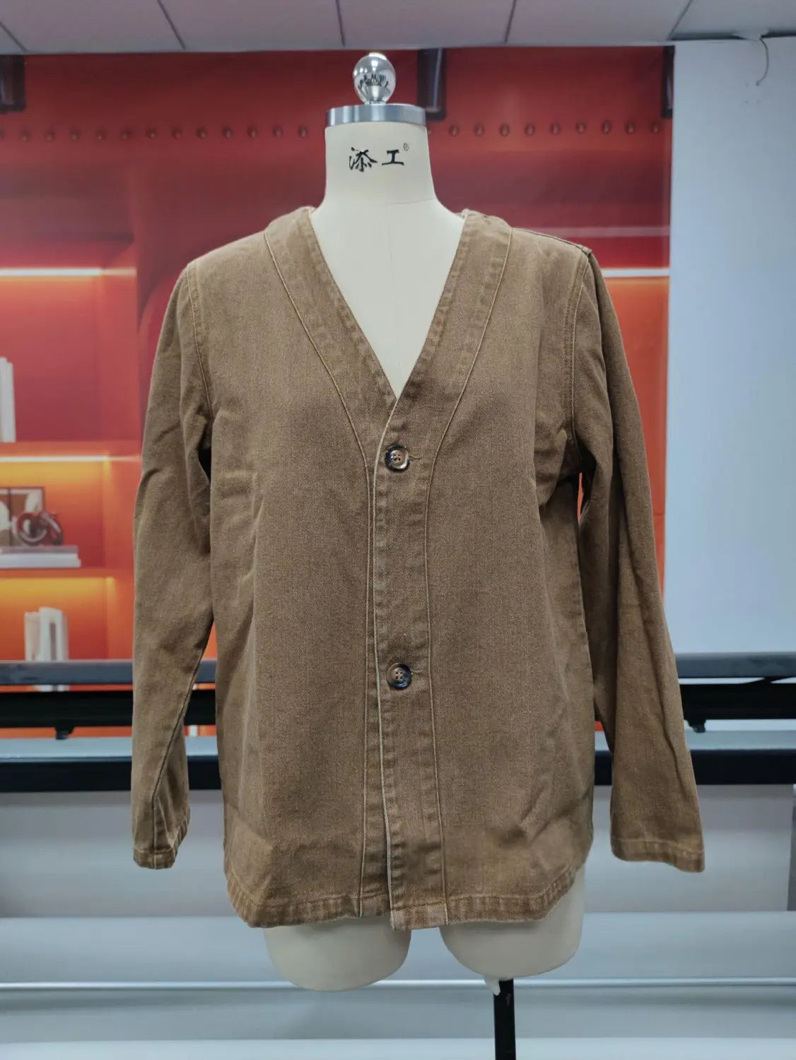 Chaqueta tipo cárdigan de mezclilla en pana color beige para mujer con cuello en V y tres botones oscuros.