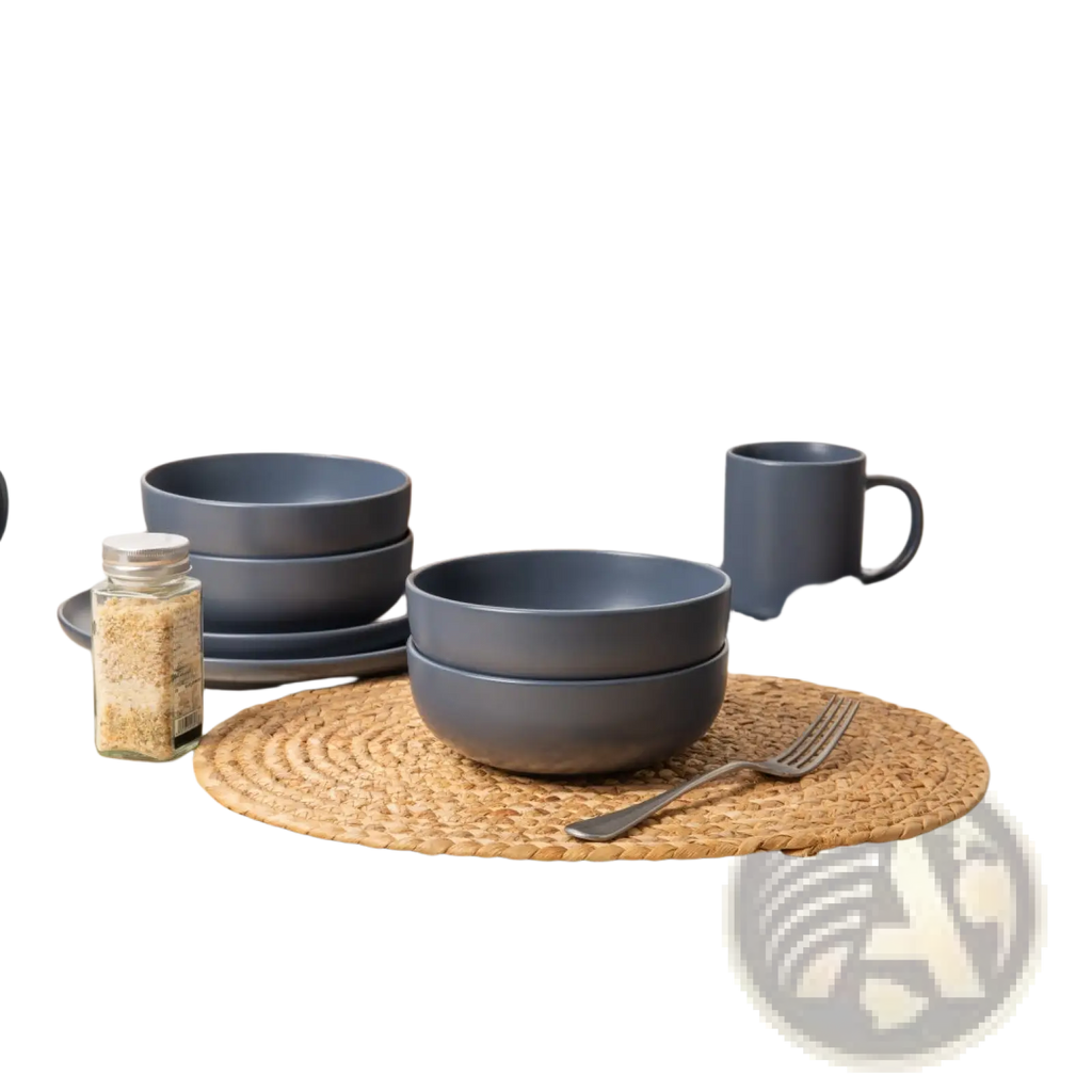 Set of matte gray ceramic stoneware bowls with rounded rims stacked on a woven placemat from a 12-piece dinnerware set