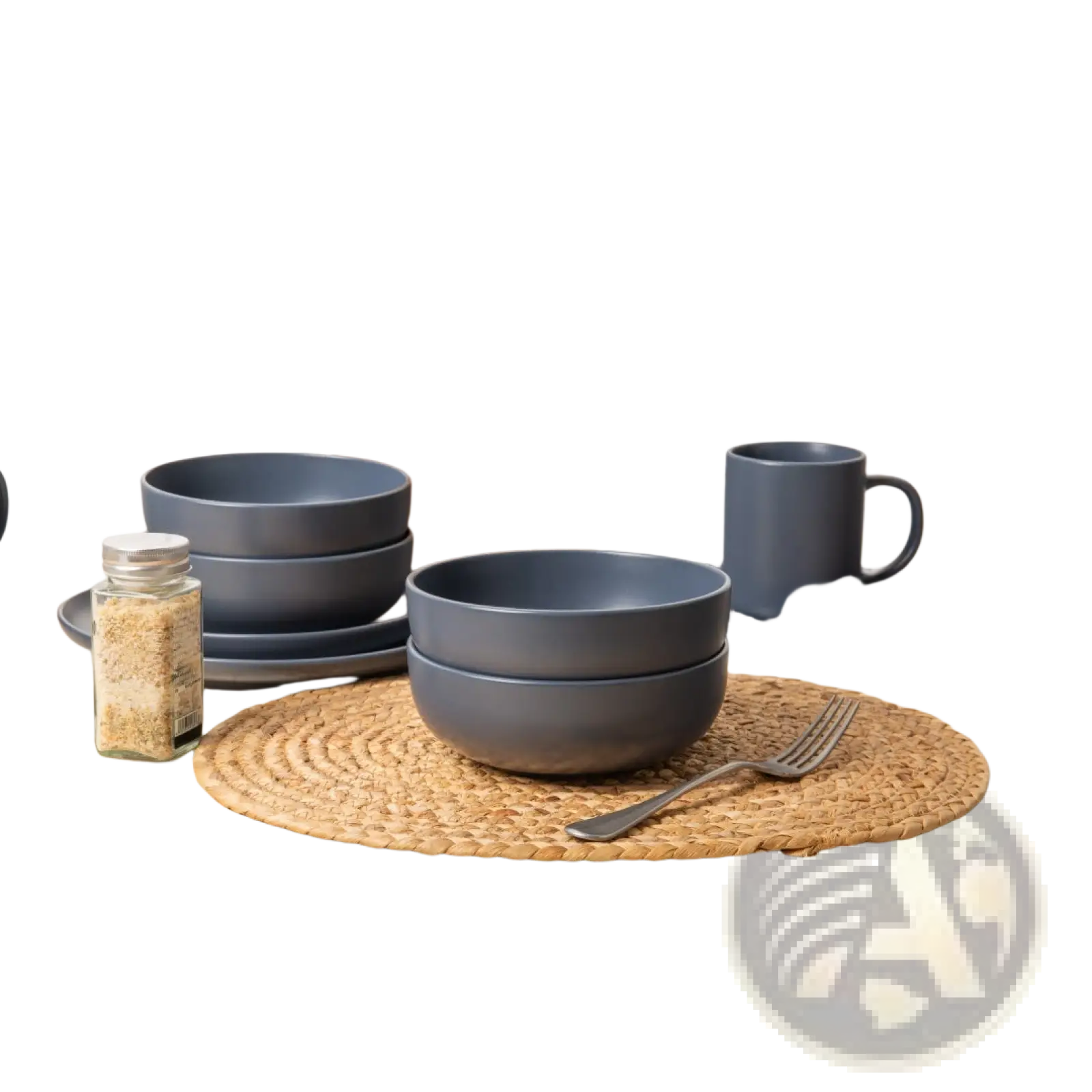 Set of matte gray ceramic stoneware bowls with rounded rims stacked on a woven placemat from a 12-piece dinnerware set