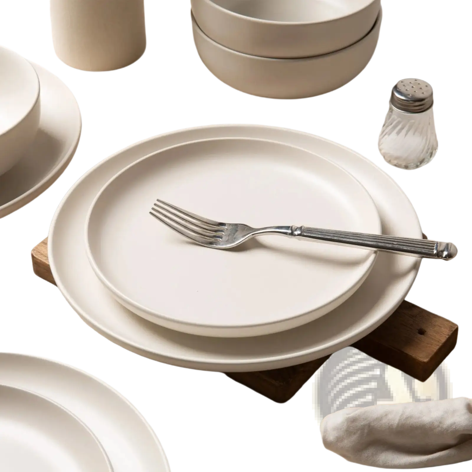 Cream-colored 12 piece stoneware dinnerware set with matte finish stacked plates and silver fork for three users