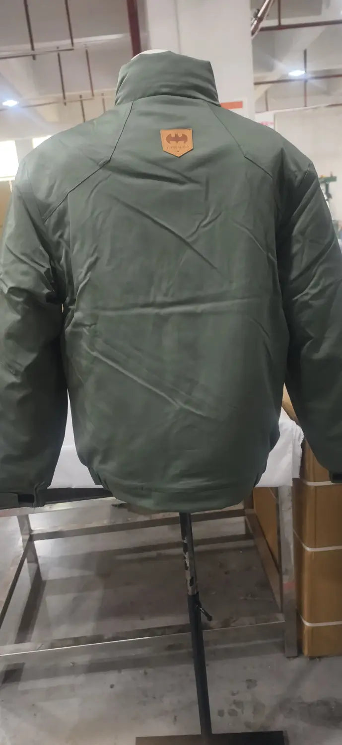 Herren-Steppjacke für Arbeitskleidung von hinten in Olivgrün im Puffer-Stil mit Steppdesign, mit einem beigen Batman-Logo-Patch.