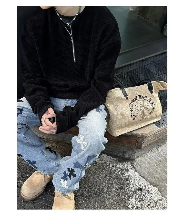Bolsa tote de lona beige con logotipo bordado negro y diseño cruzado, mostrada junto a una sudadera tipo jersey acanalada de media cremallera para hombre.