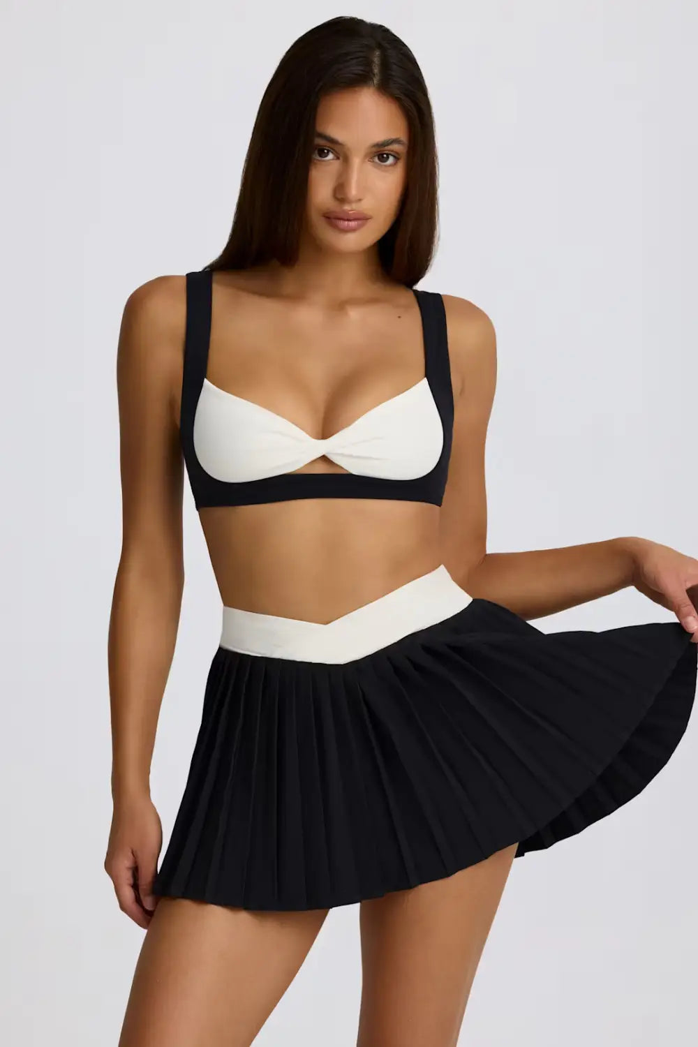 Zweiteiliges Badeanzug-Set in Schwarz-Weiß mit plissiertem Sportrock-Skort, der die Figur optisch schlankt; ideal für Activewear und Schwimmen.