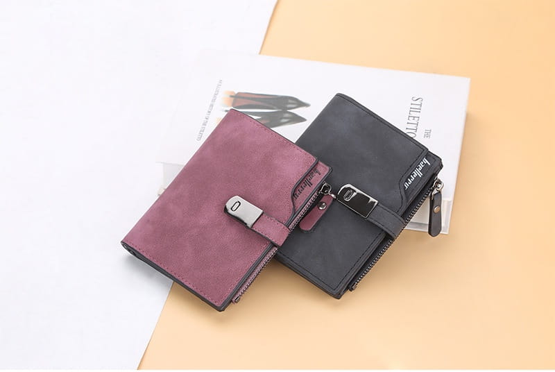 A women’s short faux leather multi slot wallet featuring a sleek minimalist design in rich burgundy suede with silver-toned hardware and a contrasting black zipper pull.