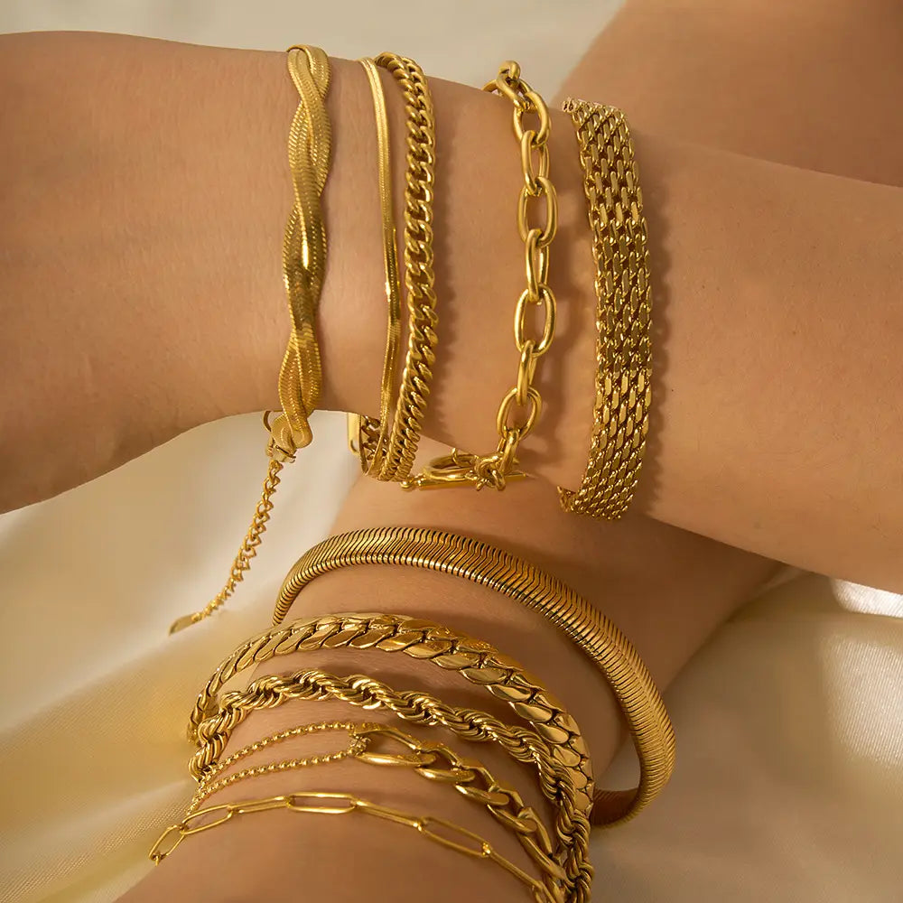 A collection of 18k gold PVD plated stainless steel chain link bracelets in various styles including twisted link and snake-like textures.