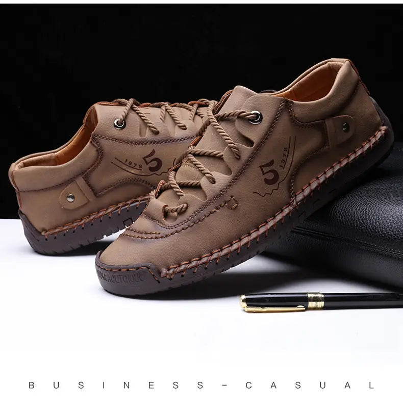 Herren-Casual-Lederschuhe im britischen Stil mit Schnürung aus braunem Leder mit sichtbarer Naht und einem „5 1879“-Logo an der Seite.