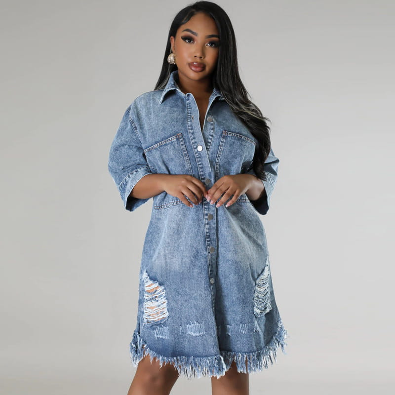 Robe chemise midi en denim, en lavage bleu délavé, avec empiècements abîmés au niveau des genoux et un ourlet effiloché