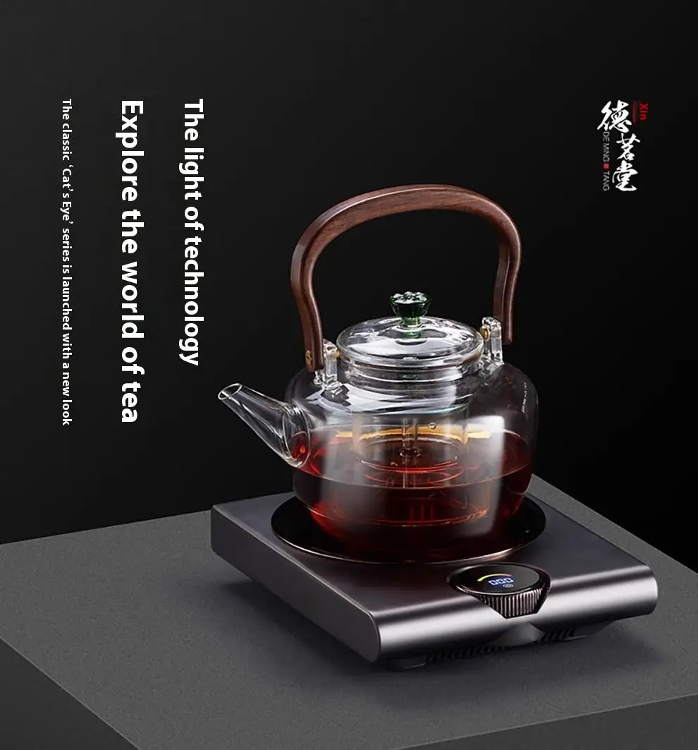 Clear glass teapot with dark brown wooden handle and lid knob resting on a sleek black electric ceramic stove 1000w tea cooker kettle heating base.