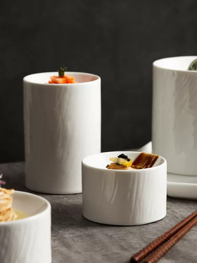 White ceramic appetizer ramekins with a matte textured wood grain finish in a bowl set.