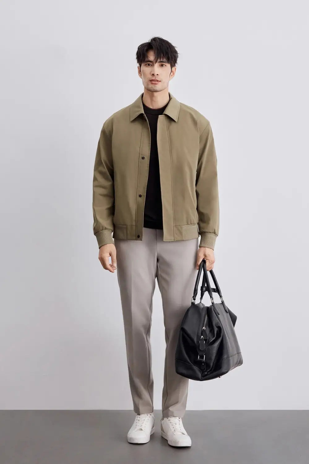 Schwarze Ledertasche im Duffel-Stil mit verstellbaren Trägern und Front-Zipper-Verschluss, passend zur Kollektion der Herren-Jacke mit gestepptem Revers, für die Geschäftsführung.