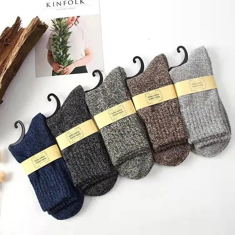 Men’s rabbit fur winter socks in navy blue, charcoal gray, brown, and heathered shades feature cozy textured knit displayed on black hangers with yellow labels.