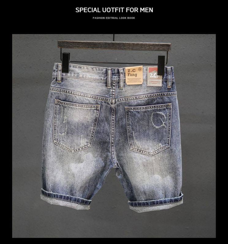 Distressed maple leaf denim shorts in faded blue with rolled cuffs and a worn-in look.
