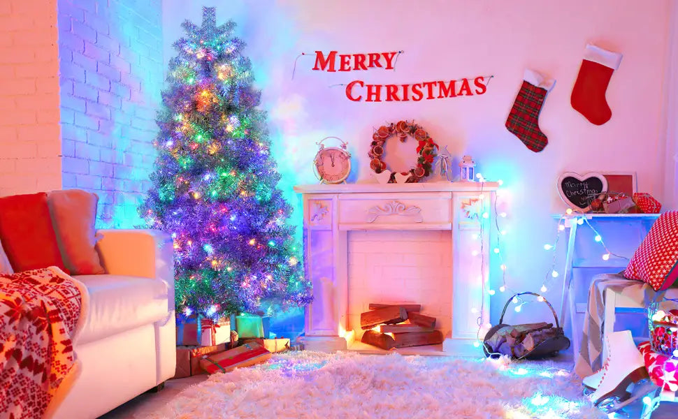 A tall silver pre-lit artificial Christmas tree with LED lights adorned with multicolored lights and wrapped presents at its base.