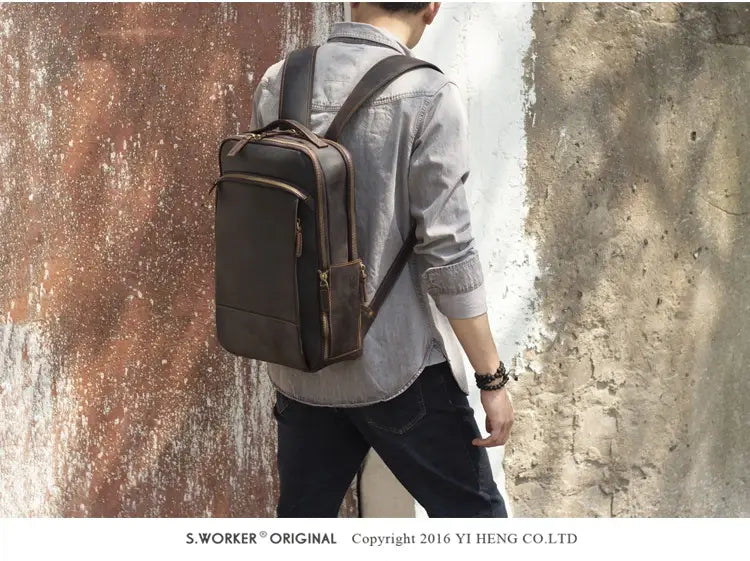 Men’s vintage leather backpack in dark brown cowhide featuring visible stitching and multiple zippers.