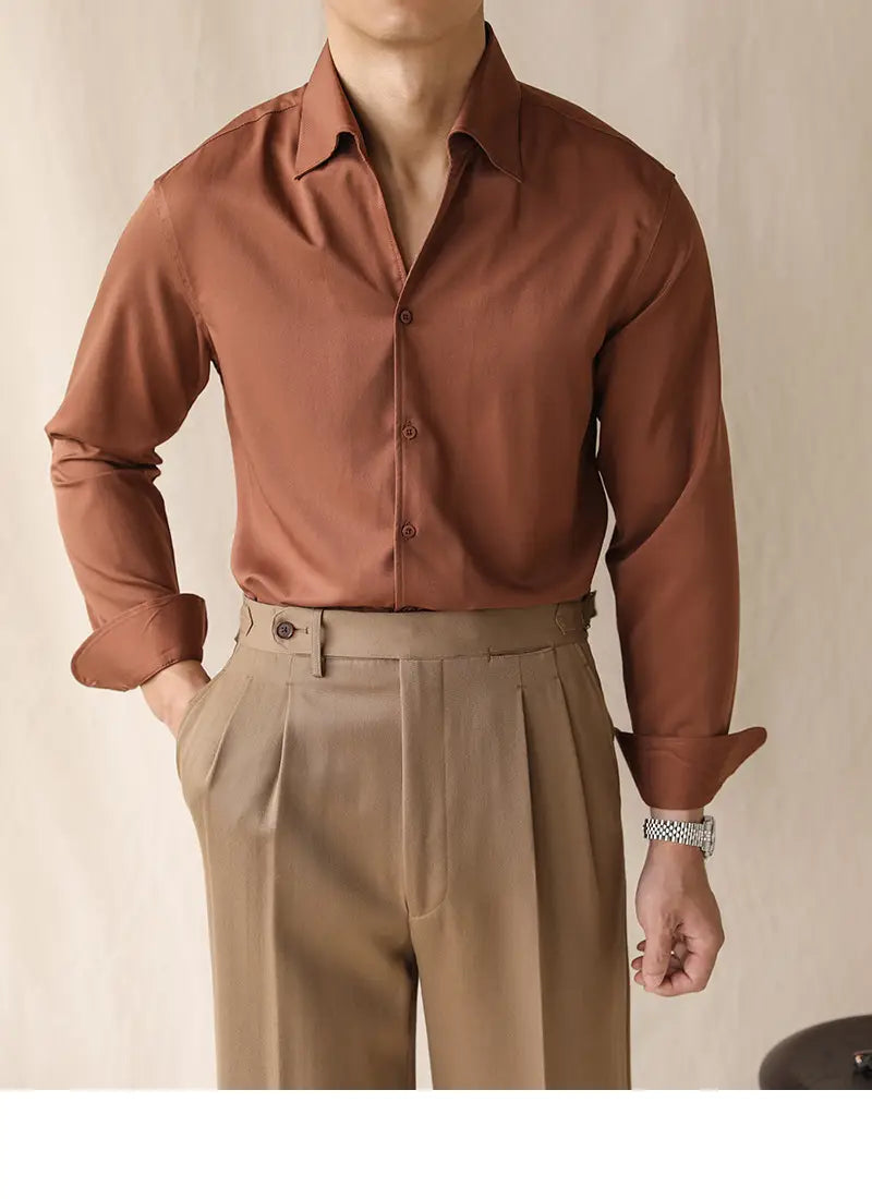 Ein elegantes Herren-Oberteil mit Ein-Kragen aus Satin in rostfarbenem Ton, langarm im Business-Stil, mit klarem Kragen und ordentlich umgeschlagenen Manschetten.