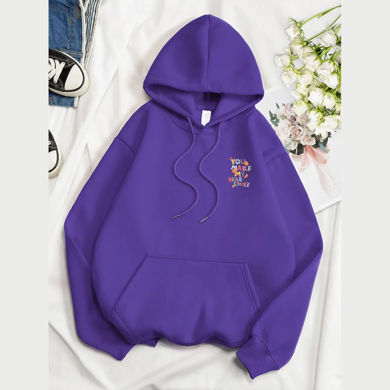 Sweat à capuche violet fabriqué dans une matière confortable, avec un motif de fruits brodé et un message « You make my heart smile » sur la poitrine, idéal pour un usage décontracté.