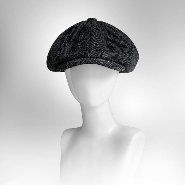 Dark gray herringbone woolen flat cap with structured eight-panel octagonal design.