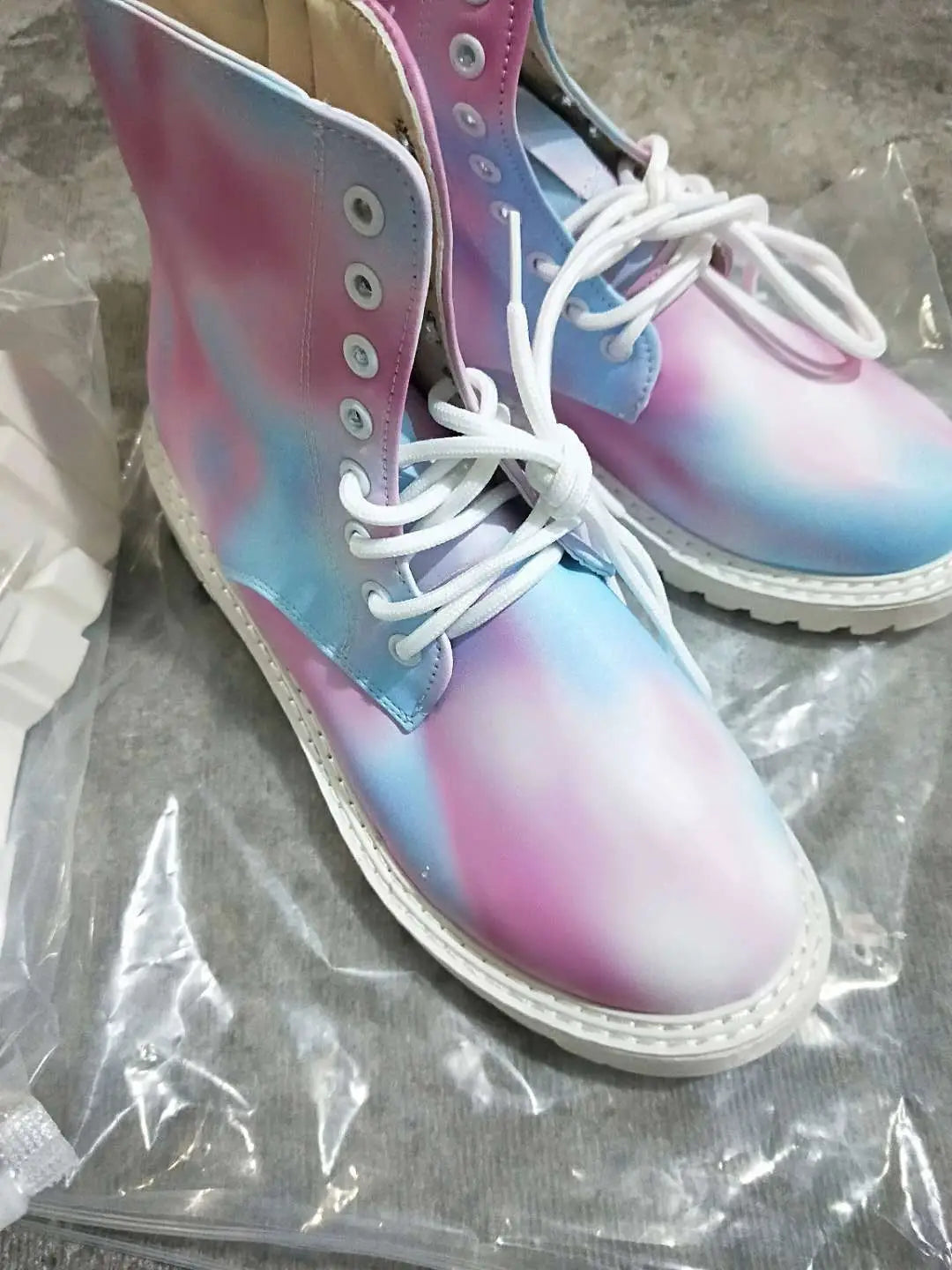 Pastellfarbene rosa- und blau-gebatikte Combat-Boots mit High-Top-Design, klobiger weißer Sohle und weißen Schnürsenkeln.