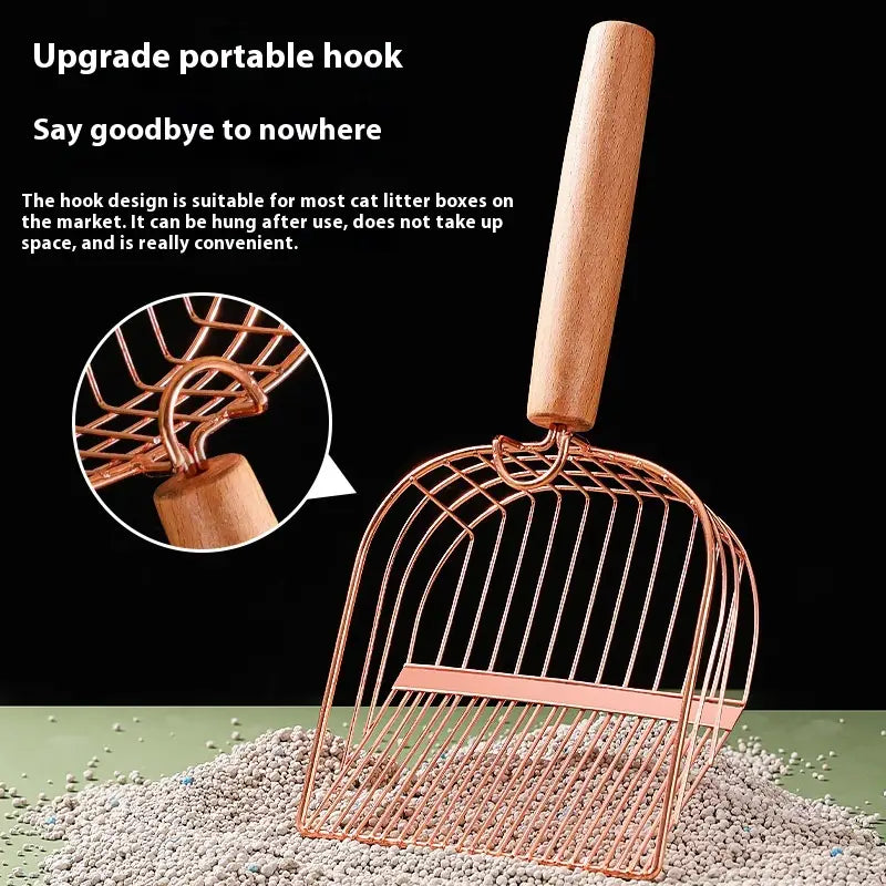 Pala para arena sanitaria de gato de metal color rosa dorado con mango de madera clara, diseñada para una limpieza eficiente de la arena para gatos.
