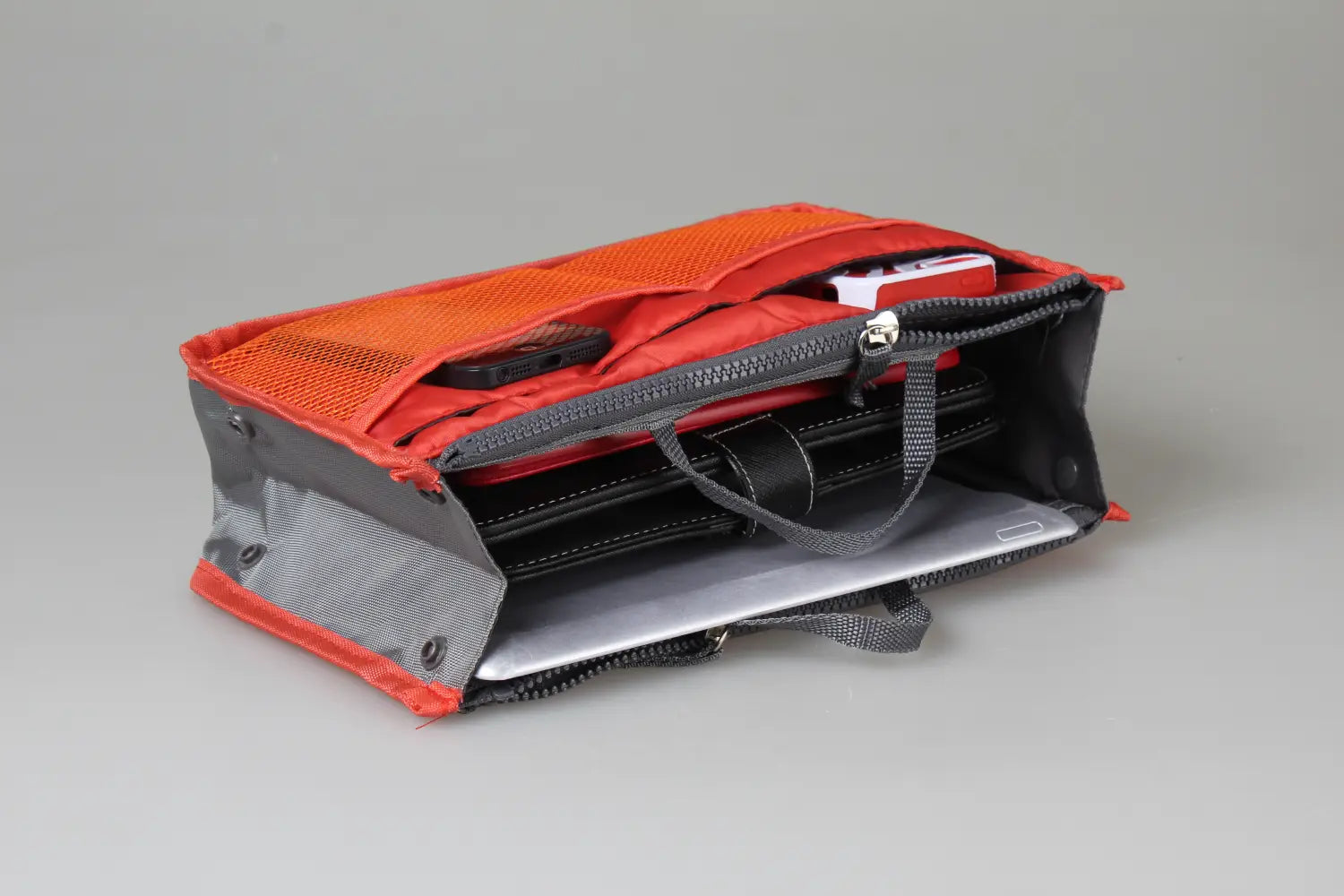 Orange and gray mesh multi-pocket nylon handbag organizer with dual zippers and multiple compartments for storing small items.