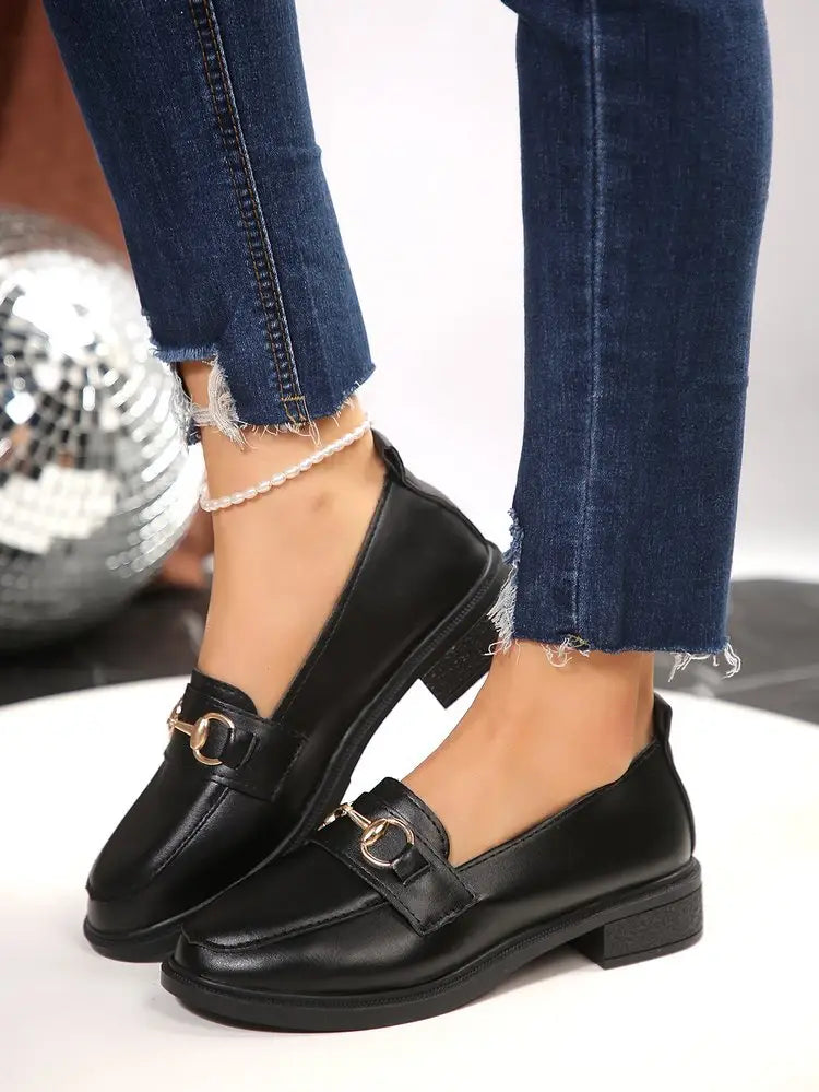 Schwarze Lederloafer für Damen mit goldfarbenem Pferdebit-Detailing und einem niedrigen, klobigen Blockabsatz.