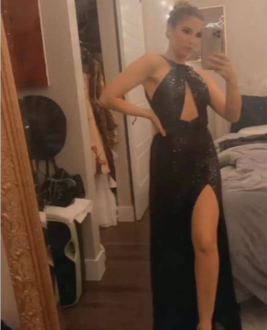A black sequined halter neck evening gown featuring a high slit and cut-out detail.