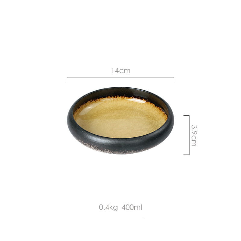 A sleek oval-shaped ceramic bowl with a glossy black exterior and warm amber interior glaze made of kiln glazed bone china.