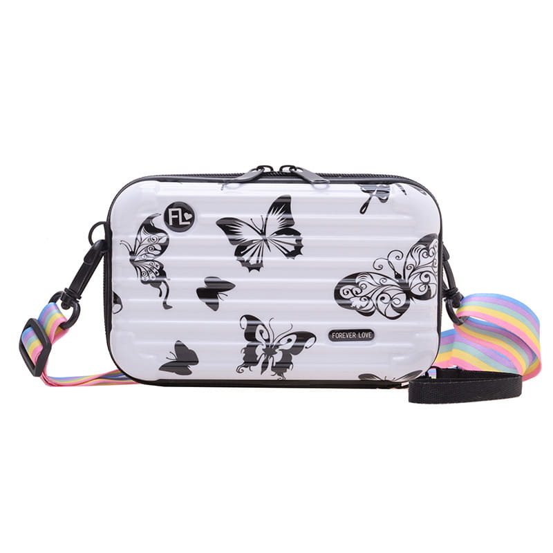 White hard-shell mini suitcase crossbody bag with black butterfly decals and a rainbow-striped strap.