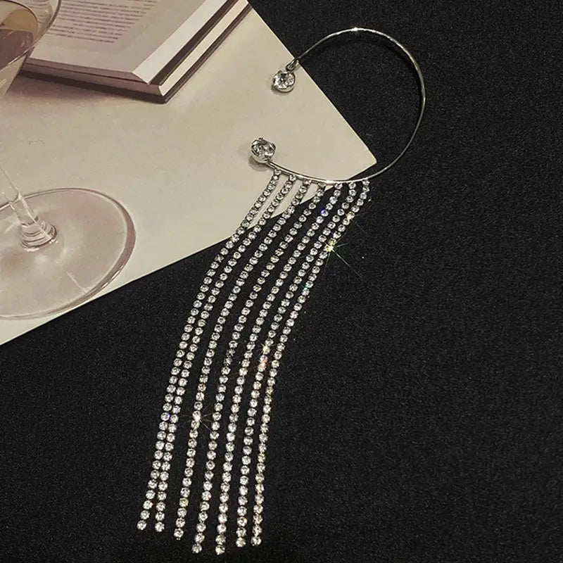 Silver rhinestone ear cuff featuring cascading strands of sparkling crystals designed as crystal tassel 14k gold plated long drop earrings.