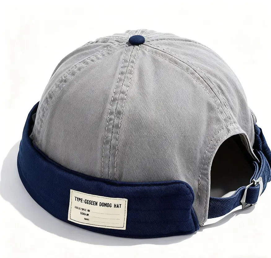Canvas fedora hat for men with adjustable denim strap in gray and navy blue featuring a folded brim and dark blue button on top.