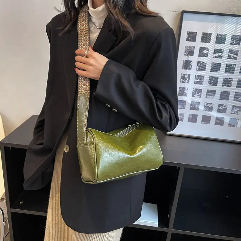Olive green patent leather retro crossbody bag featuring a textured gold woven patterned strap.