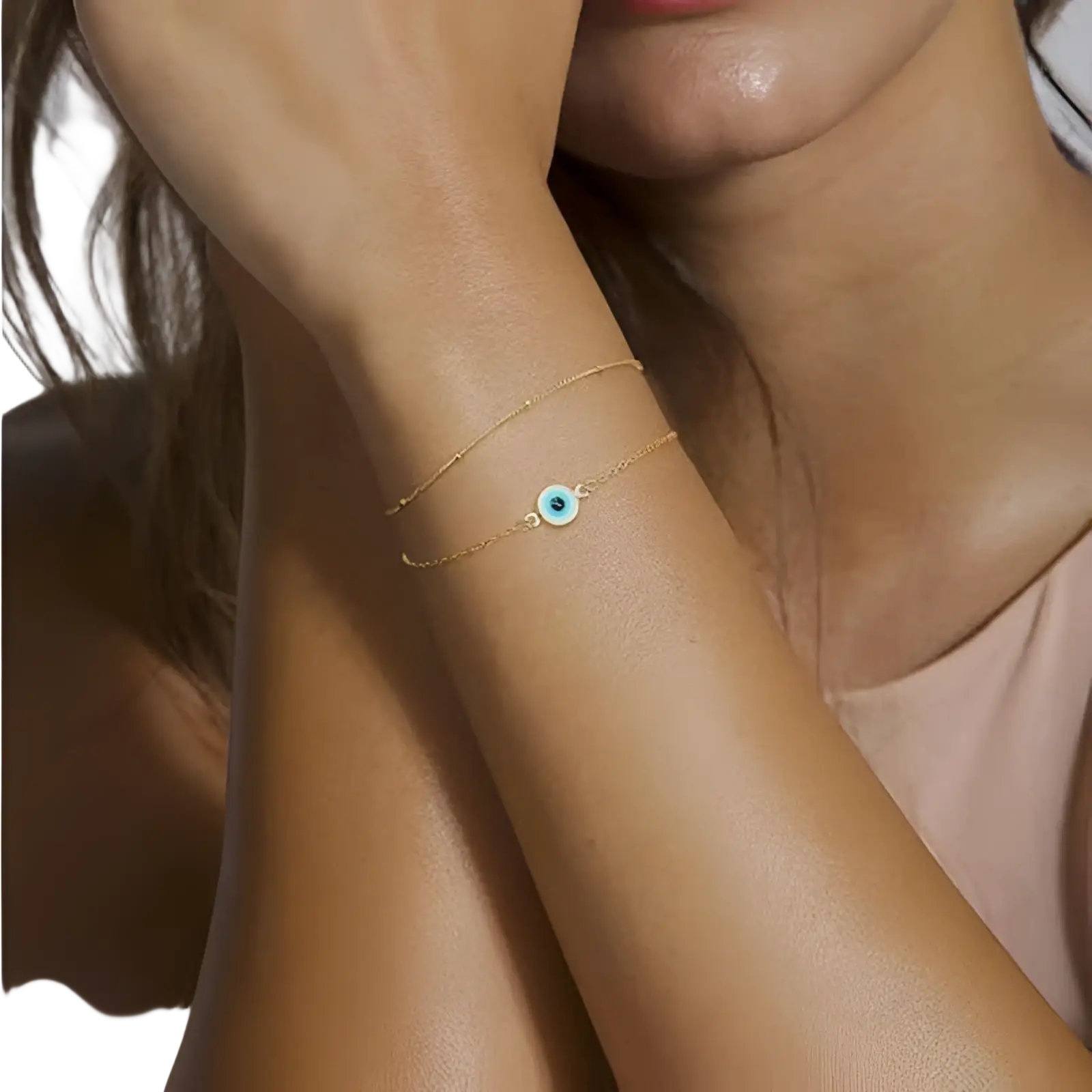 Delicate 14k gold filled layered bracelet with a small round blue evil eye charm and adjustable chain design