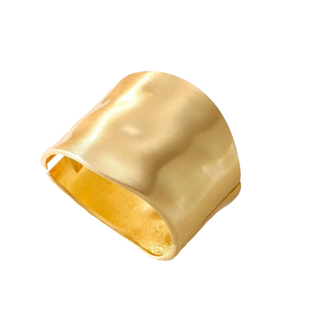 A wide hammered 14k gold plated cuff bracelet with a smooth interior and textured exterior gold bangle for women