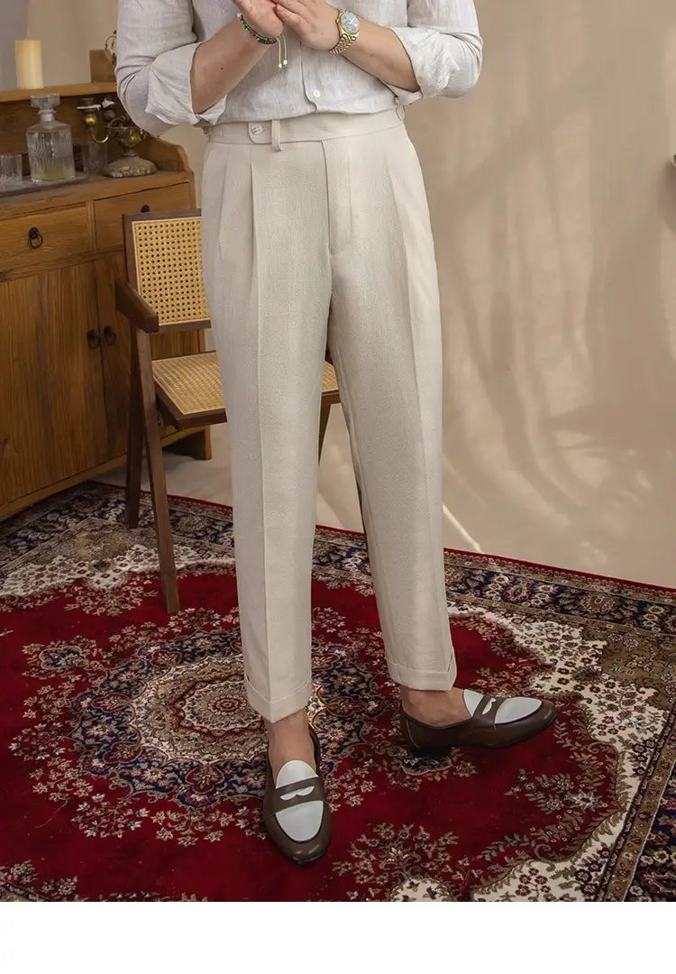 Men’s slim fit pleated summer linen suit trousers in cream color with a tailored fit and buttoned waistband.