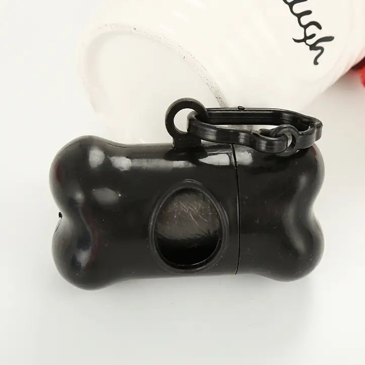black plastic bone-shaped dog waste bag dispenser with keychain loop for easy carrying shown from the back side included in the bone dog waste bag dispenser and 300 refill bags product package