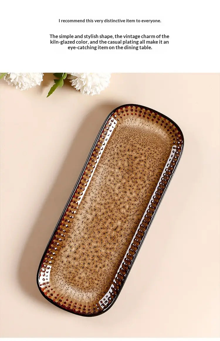 A rectangular ceramic serving tray with a textured kiln-glazed surface in warm brown tones and darkened edges measuring 12.5 inch.