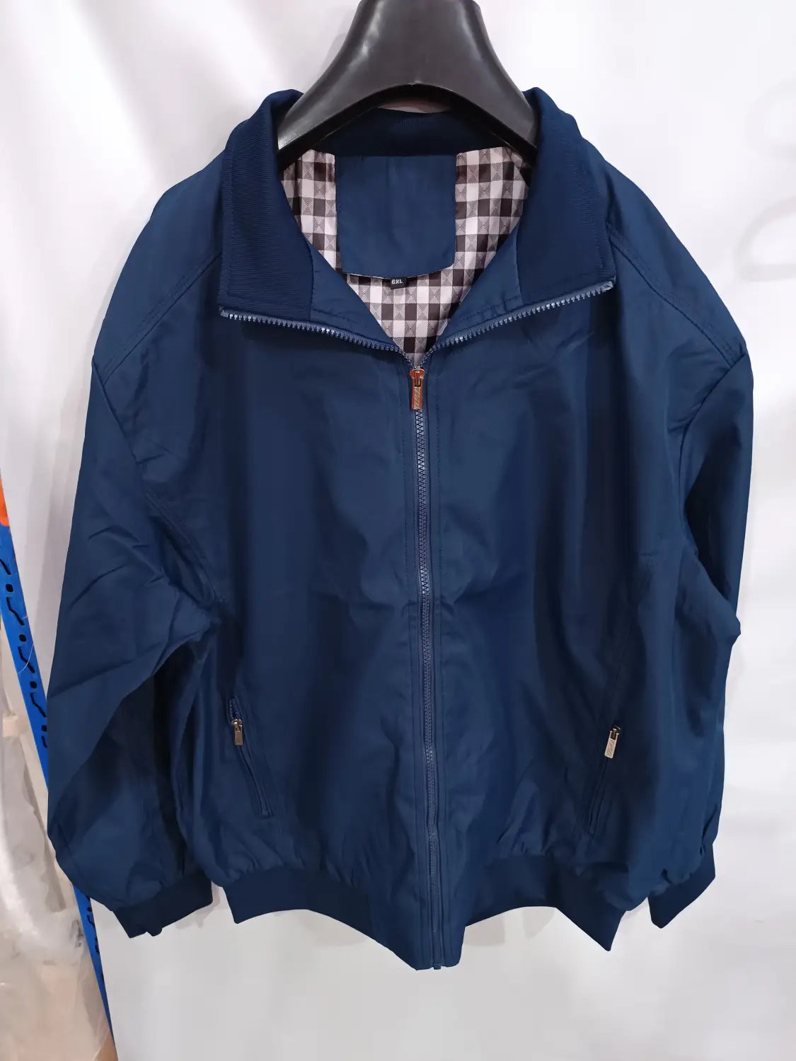 Veste bombardier légère pour homme bleu marine, avec fermeture à glissière frontale et doublure intérieure à carreaux en matériau respirant.