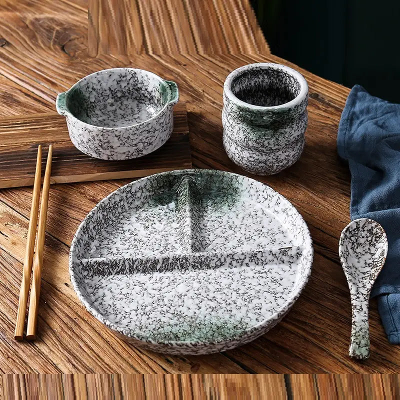 Service d’assiettes de dîner divisées en céramique avec glaçure à mouchetures, comprenant une assiette en céramique blanche avec des éclaboussures noires et un rebord dégradé vert, divisé en trois sections par de légères nervures.