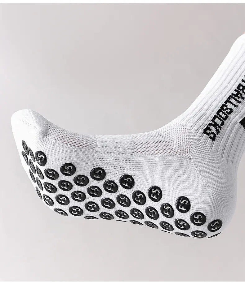 white grip socks for men with black circular anti-slip patterns on the sole and squat socks branding along the ankle designed for football.