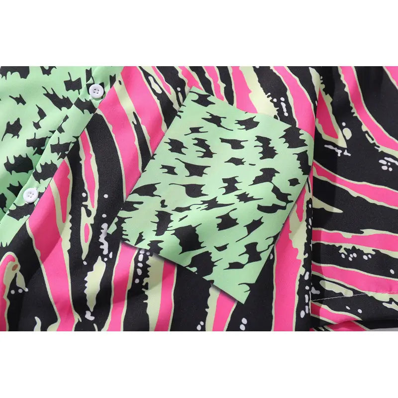 Split animal print pink and green short sleeve shirt featuring a vibrant neon green and black bat pattern with bold pink zebra stripes and white buttons.