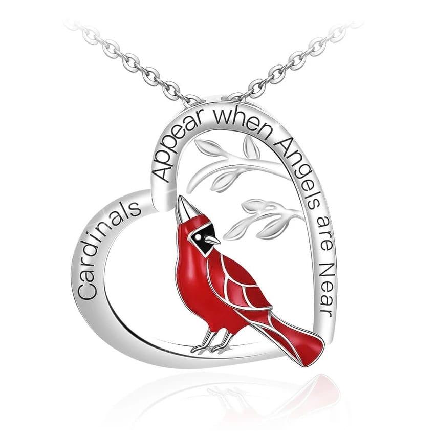A silver heart-shaped pendant necklace featuring a vibrant red cardinal with black accents and engraved text along its curve.