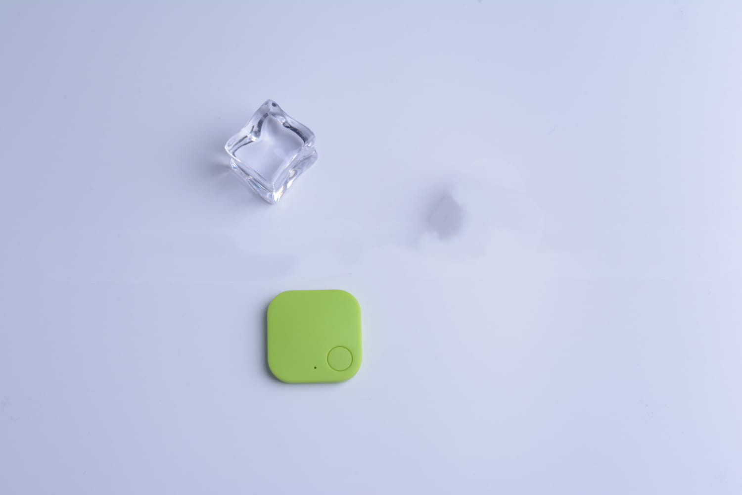 a lime green square-shaped bluetooth tracker with a circular button and small dot on its surface from the bluetooth tracker 4 pack anti lost gps key finder set