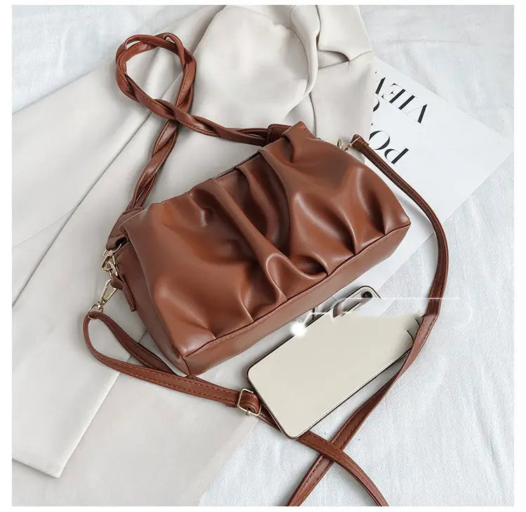 Brown pu leather pleated crossbody bag for women featuring a braided strap and soft ruched design.
