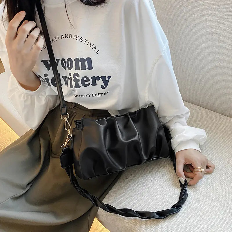 Black pu leather pleated crossbody bag for women featuring a braided strap and gold-tone hardware.