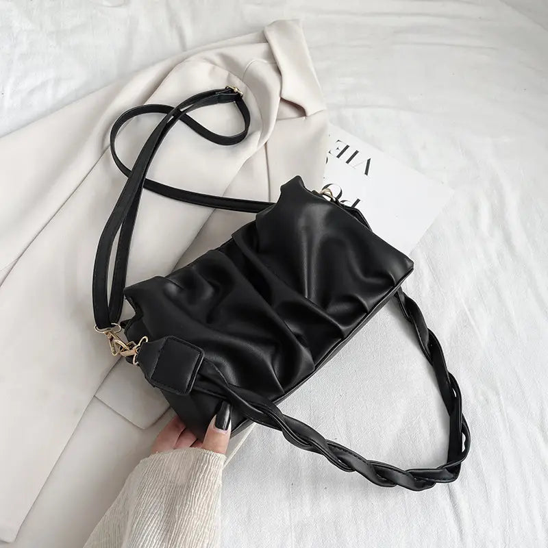 Black pu leather pleated crossbody bag for women featuring a ruched design and braided strap.