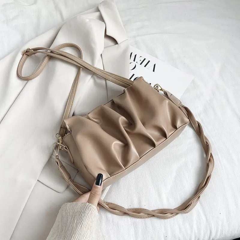 Beige pu leather pleated crossbody bag for women with a braided strap and gold-tone hardware.